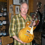 Tom Wittrock holds one of his prized guitars, "Sandy," at Third Eye Music.